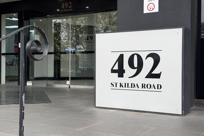 A building with a large sign saying 492 St Kilda Road in black and white.