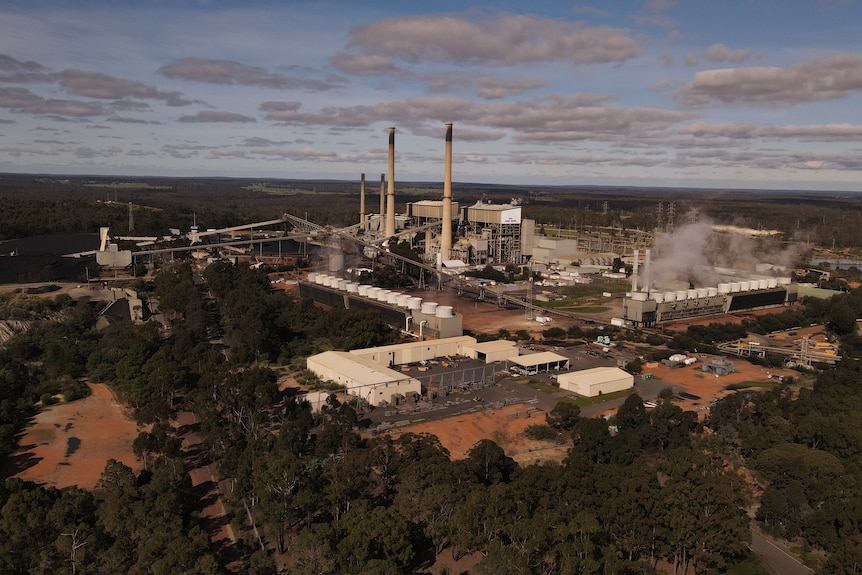 Aerial views of a large industrial coal-fired power plant site with four chimneys and coal stockpiles.