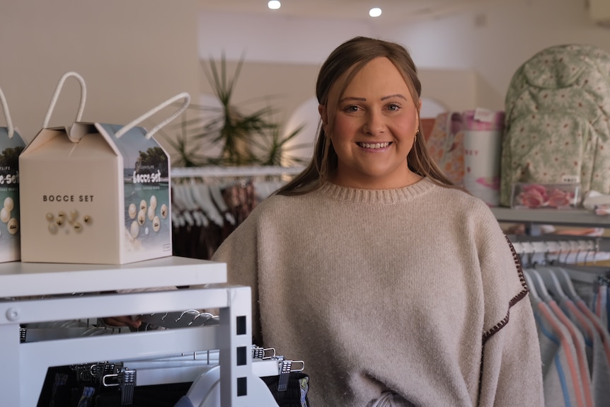 A woman wearing a beige top in a shop