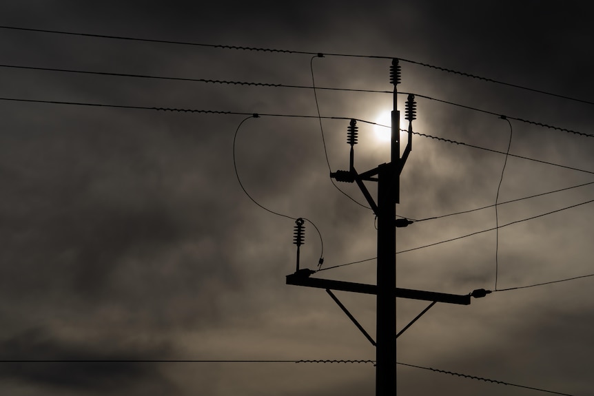 A view of the top of a power pole on a cloudy day.