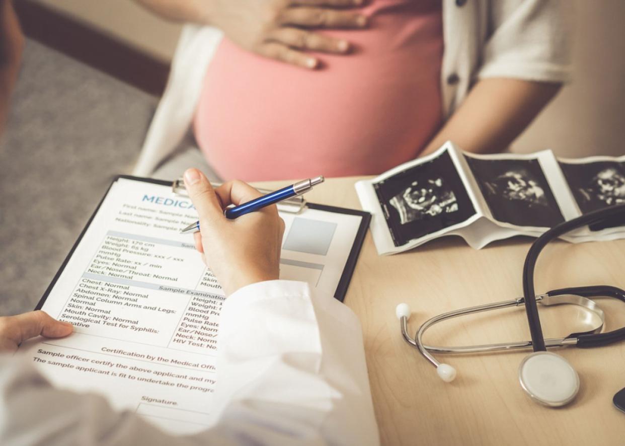 Pregnant woman with ultrasound visiting obstetrician. -