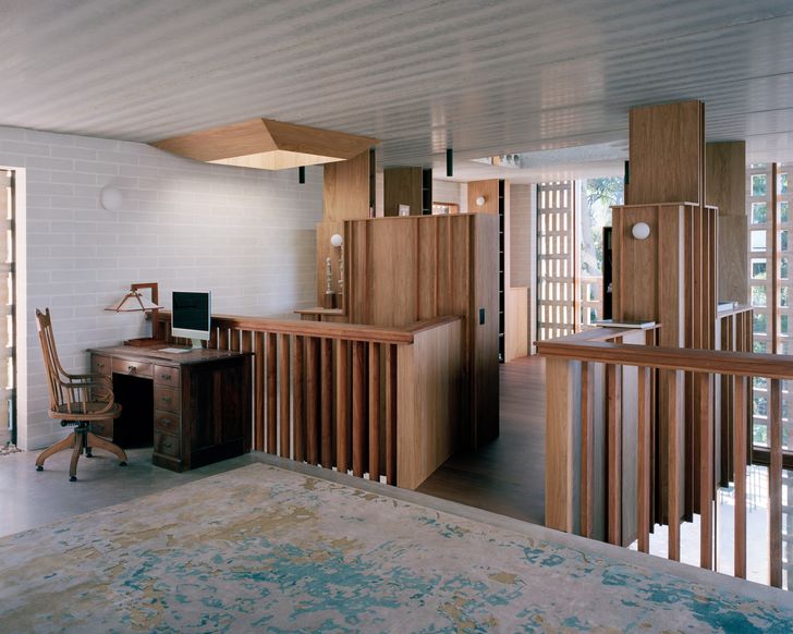 The suspended library pod’s high shelving is cut away to maintain visual continuity with the surrounding landscape.