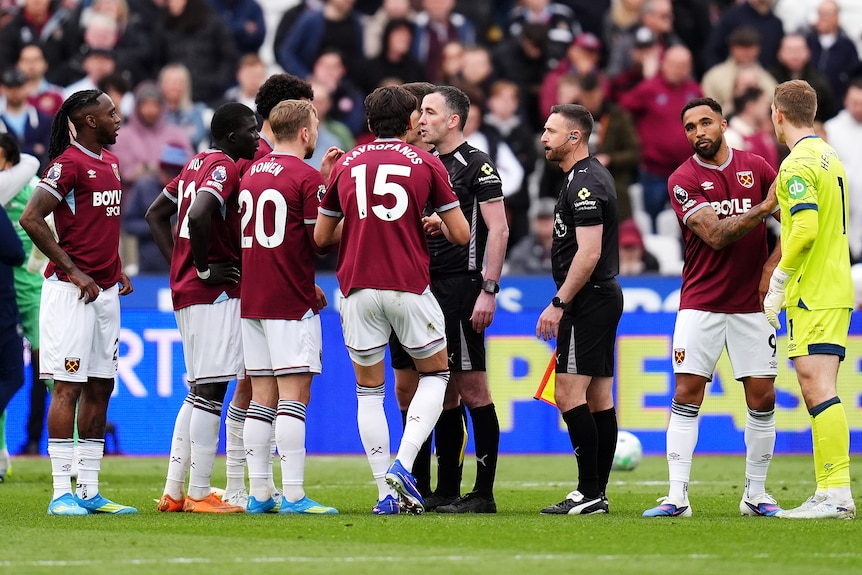 West Ham players surround the referee