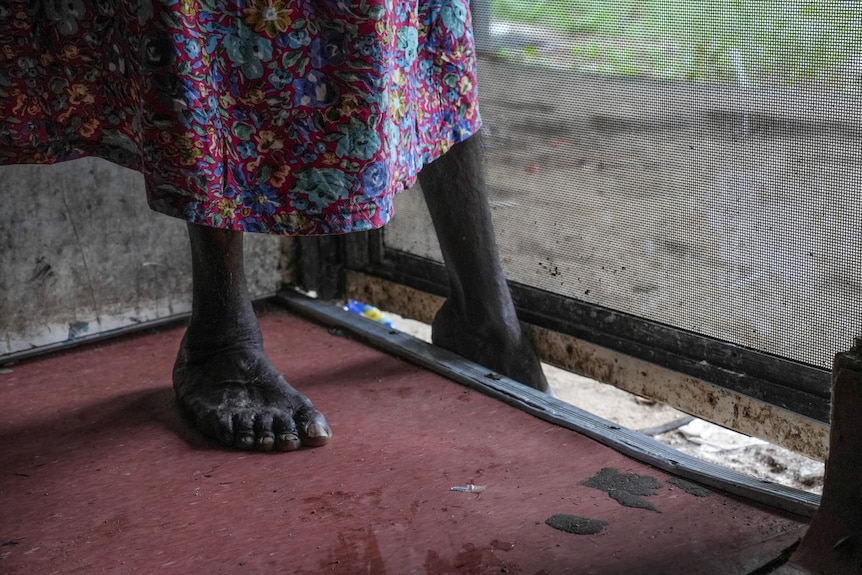 An Aboriginal woman's foot in between door and floor