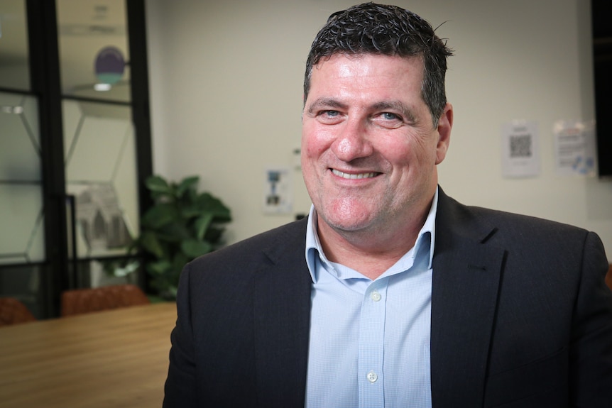 Brett Casey, a man wearing a suit, smiling. 