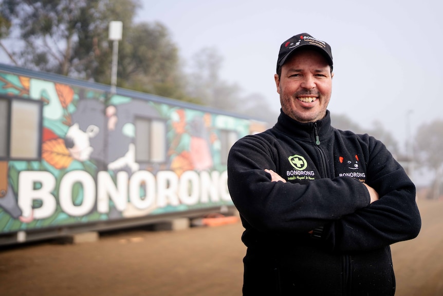 Man smiles for photo in front of shed that says 'BONORONG'