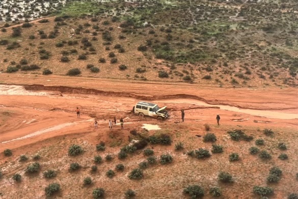 An aerial image of a car and seven people in the bush 