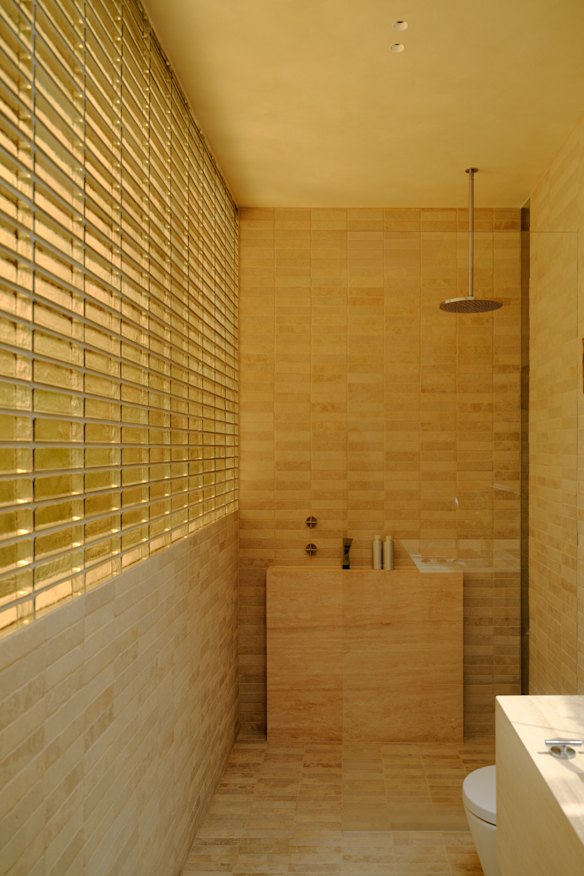 The travertine-lined bathroom