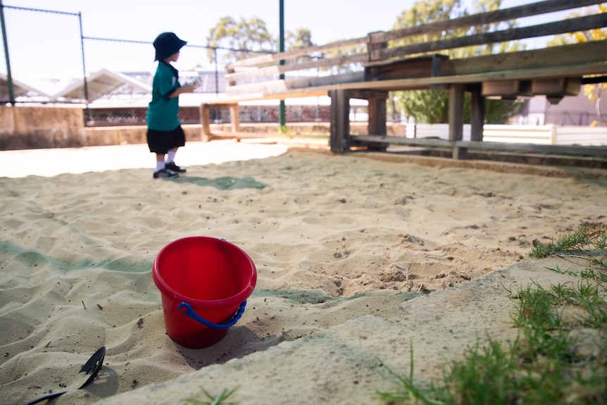 An unidentifiable child plays in a sandpit.