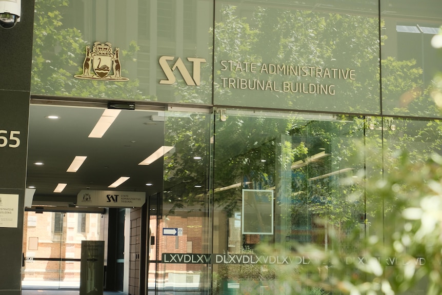 A glass wall with the words 'State Administrative Tribunal' written on it. 