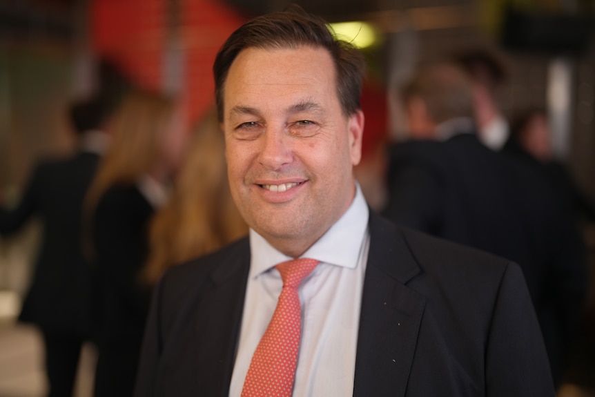 Man wearing a suit with a red tie.