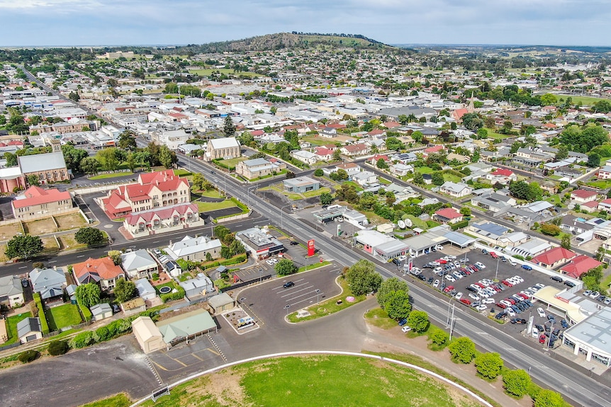A drone photo of a small city with a volcano behind