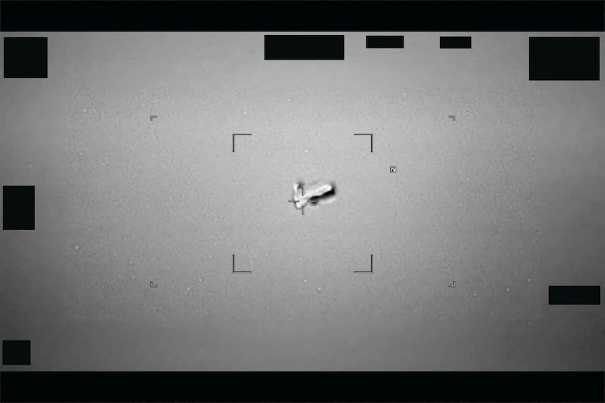A football-shaped UFO in grainy black and white image