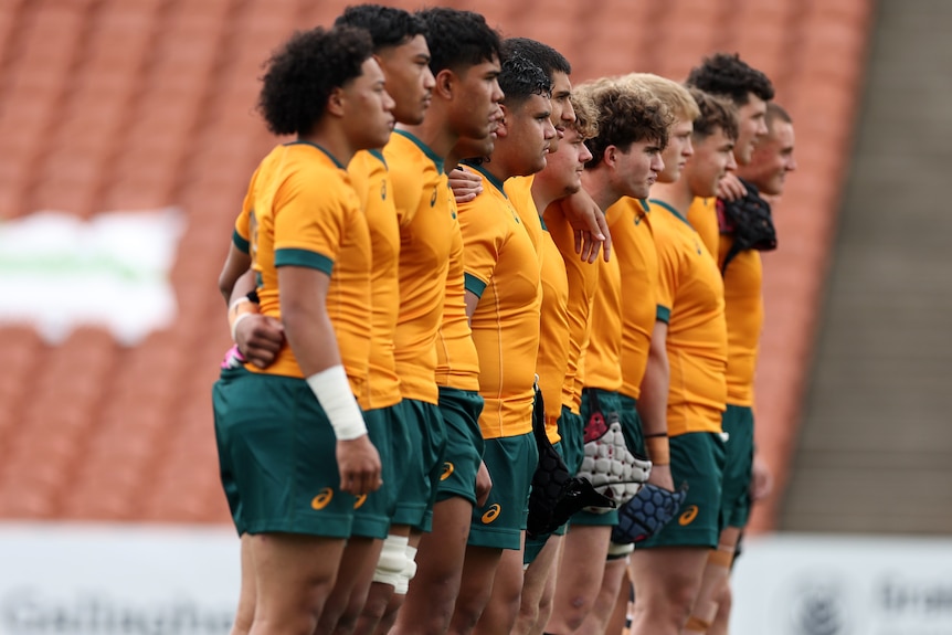 Australian U18 players line up for the national anthem ahead o fplaying New Zealand Schools in 2024.