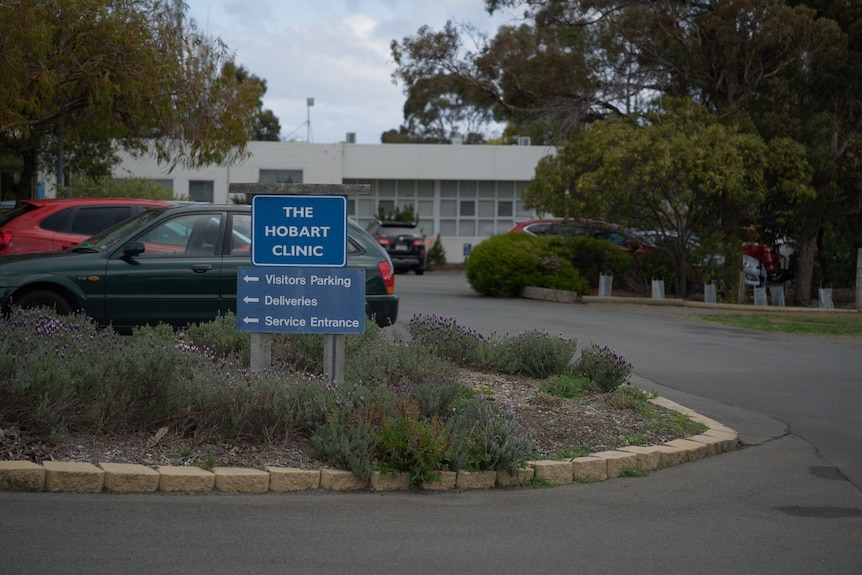 A driveway with a sign denoting The Hobart Clinic, with the clinic buildings visible in the background.