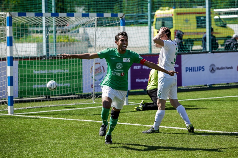 A footballer in a green kit scores a goal at the Street Child World Cup