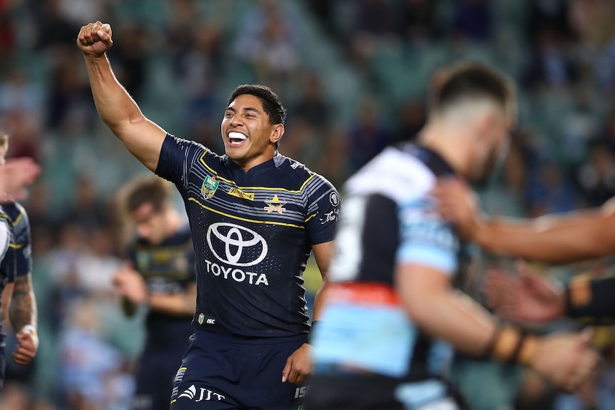Jason runs the ball during a rugby league match.