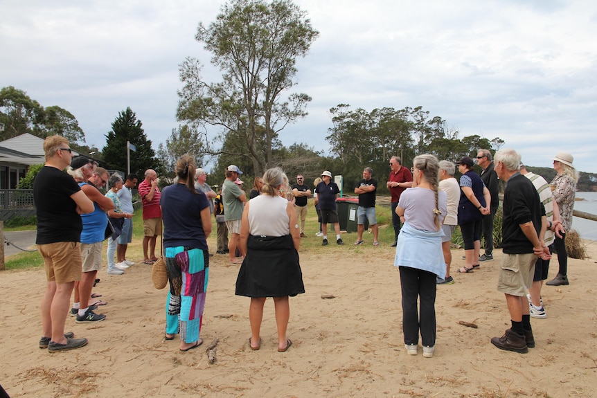 A group of people on a beach at a meeting