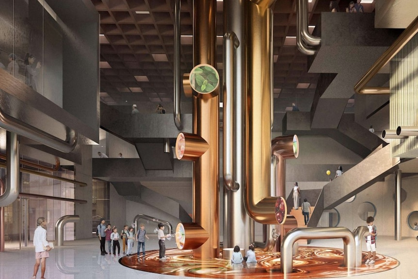 A large room with a large copper pipe installation in the centre with people standing looking at it.