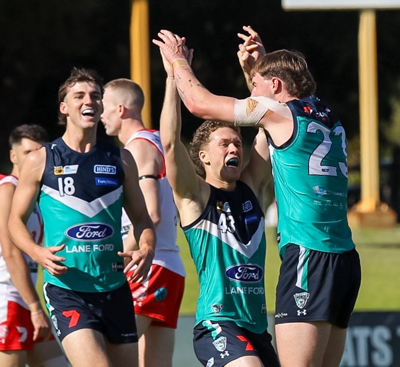 Charlie Nicholls and Toby Jenkins celebrate with Corey Tregenza after a goal.