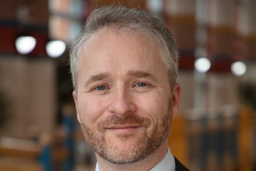 A man in a suit smiling