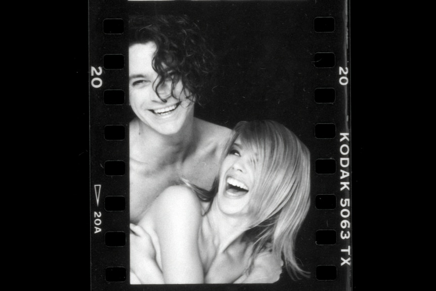 Black & white image of Kodak photo print of Michael Hutchence & Kylie Minogue topless sharing a laugh