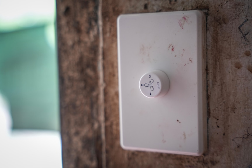 A white fan switch attached to wall