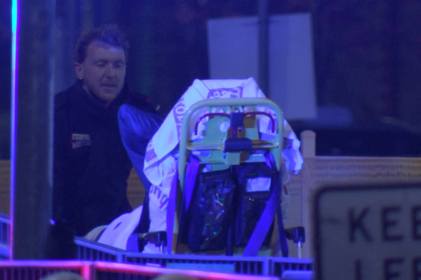A paramedic and a person on a stretcher.