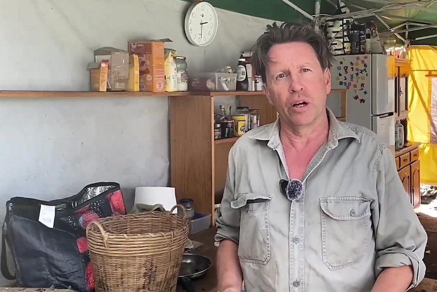 A man stands next to shed like area 