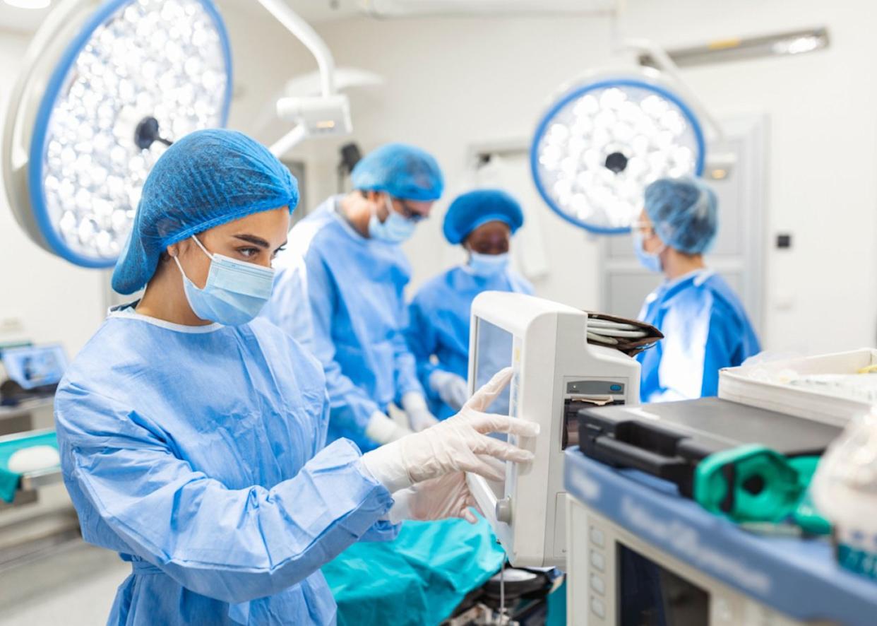 Anesthetist assistant tracking vital functions during surgery. -