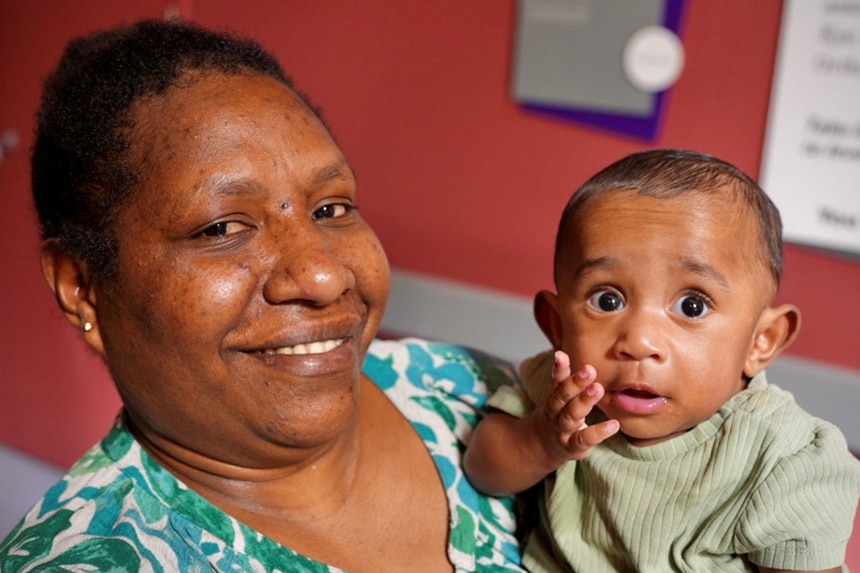 Fatima Tinga smiles while holding her baby son in hospital.