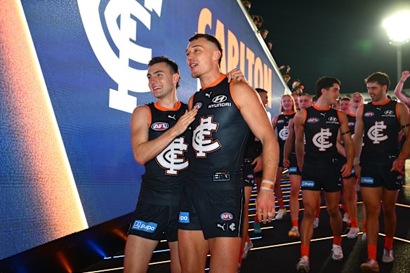 On for young and old: Jagga Smith and Patrick Cripps lead the Blues off the ground into their rooms to sing the song.