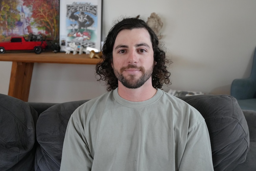 A headshot of a man sitting on a couch.
