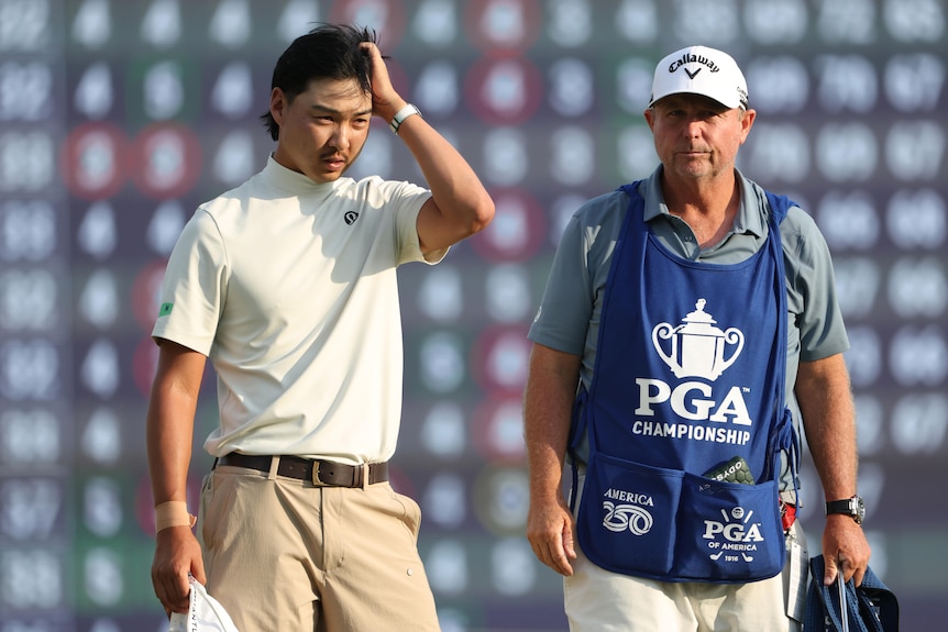 Min Woo Lee scratches his head alongside his caddy at the PGA Championship.