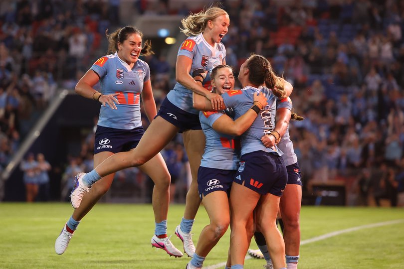 Jessica Sergis of the Blues celebrates a try with teammates