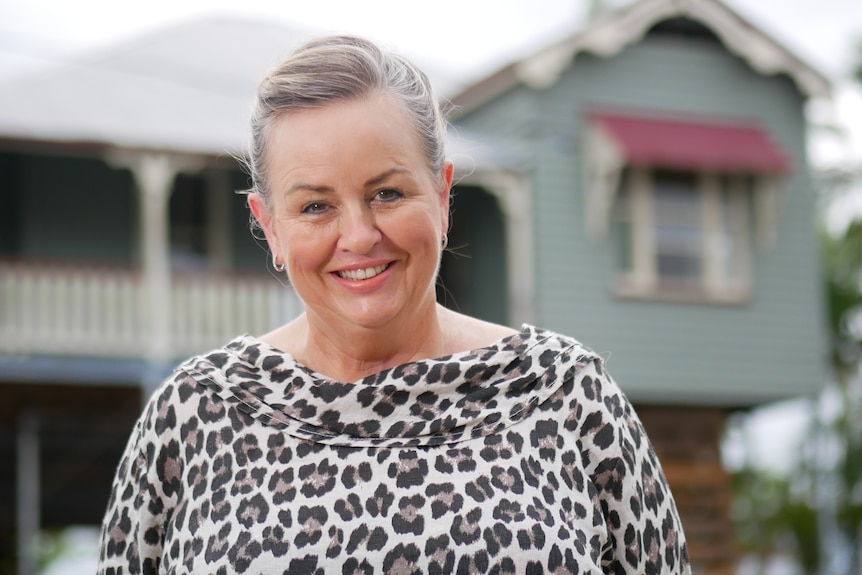 woman smiling with home in the background