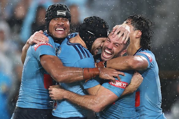 Blues fullback James Tedesco celebrates scoring the winning try with his teammates.