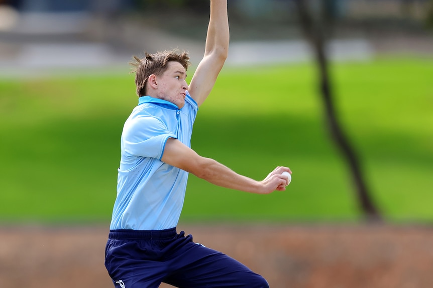 Toby Derrick about to bowl a ball in a cricket match.