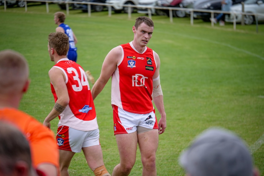 A tired footballer comes off the field