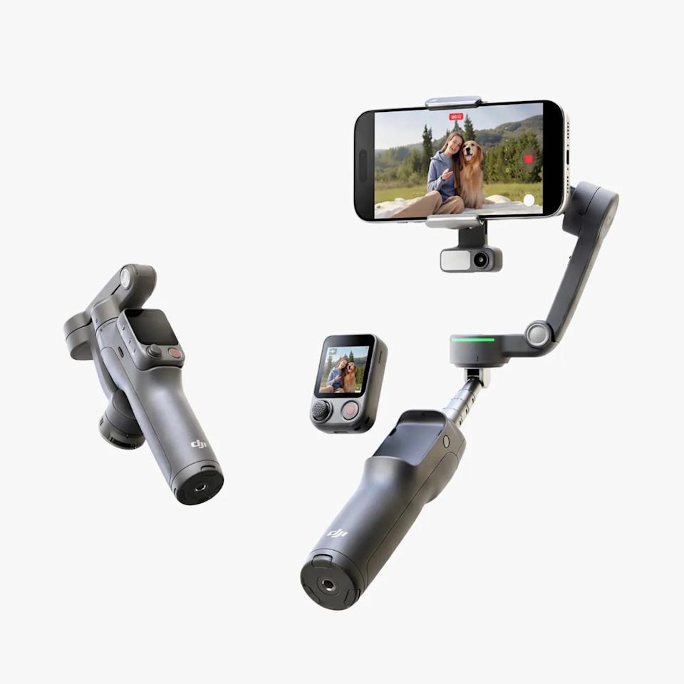 Two black DJI handheld gimbals, one holding a smartphone showing a woman and dog on screen, and a small remote control with display.