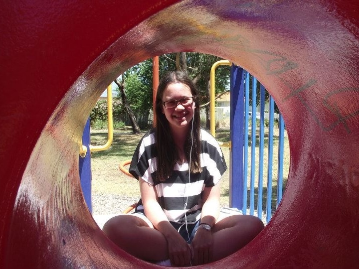 Julia Faragher as a teenager, at a playground. She is smiling.