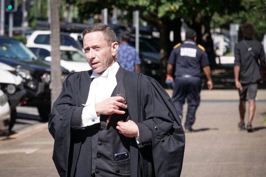 A male barrister in robes on a footpath