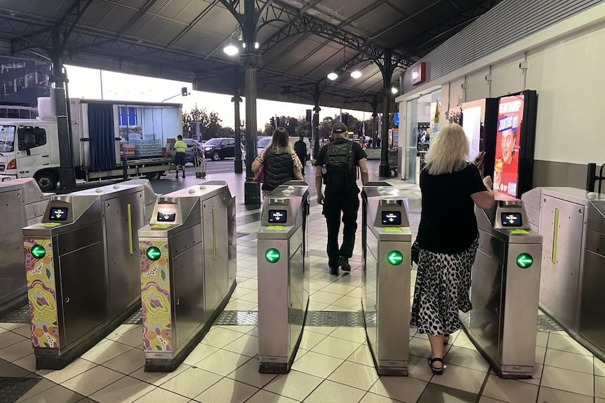 A woman walks through open ticket barriers at Flinders Street Station in Melbourne.