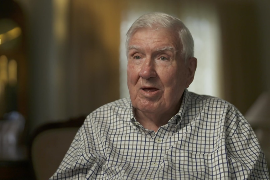 An older man faces the camera