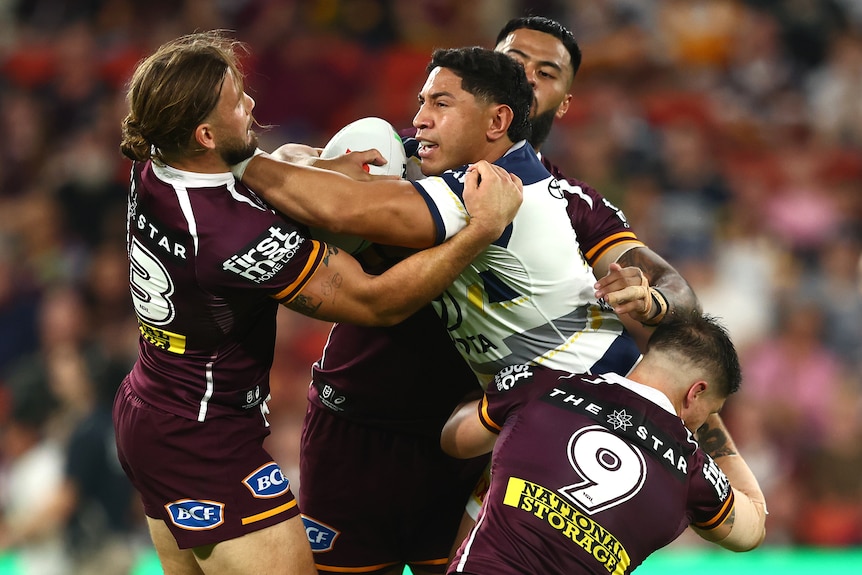 Jason runs the ball during a rugby league match.