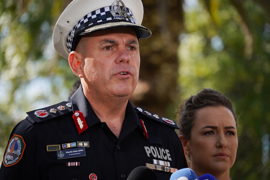 A uniformed police officer speaks to the media