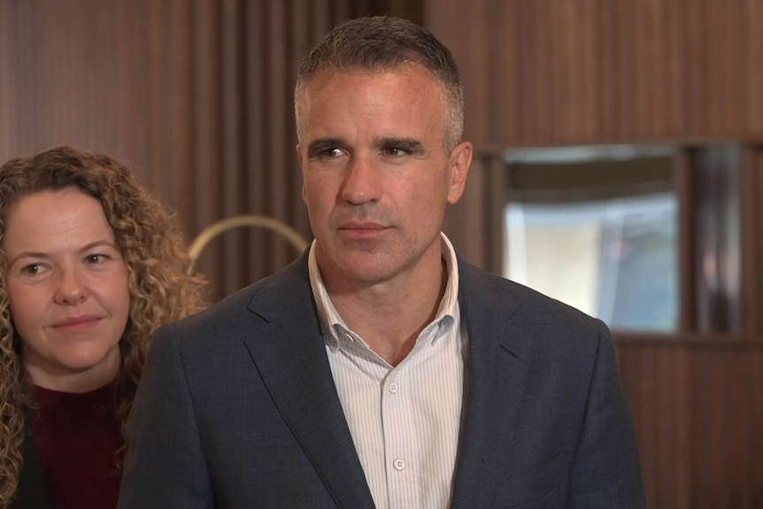Peter Malinauskas fronts the media with Nadia Clancy in a pub with timber walls.