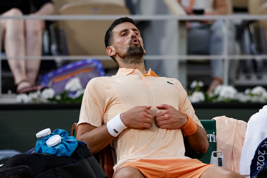 Novak Djokovic takes in a deep breath while sitting