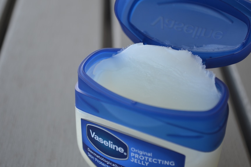 White ointment in Vaseline container, blue and white.