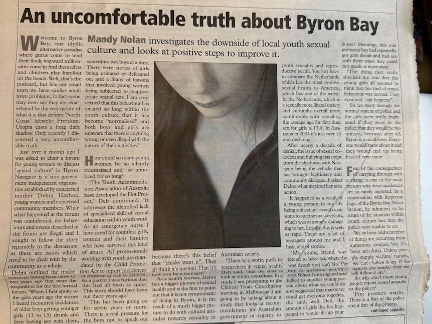 A news article under the headline 'An uncomfortable truth about Byron Bay' with a black and white image of a woman looking down